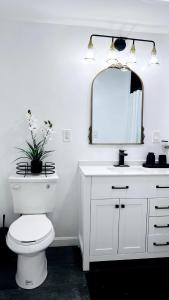 a bathroom with a white toilet and a mirror at Chic City Guesthouse Getaway in Riverside