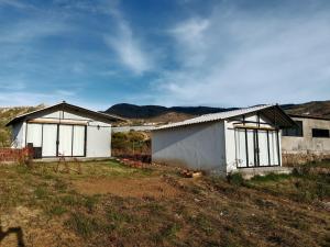 a couple of white buildings in a field at Home Glamping Deluxe in Sáchica