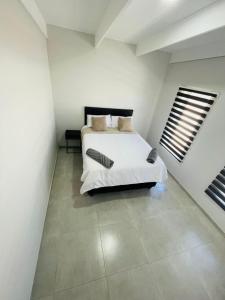 a bedroom with a bed in a white room at 44 Staycation Beach-house in Britannia Bay