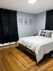 una camera da letto con letto, tende nere e pavimenti in legno di Home away from Home- 1Bd 1Ba a Woonsocket