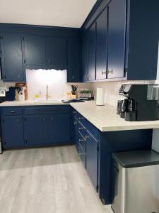 una cucina con armadi blu e piano di lavoro bianco di Home away from Home- 1Bd 1Ba a Woonsocket