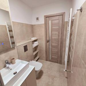 une salle de bains avec un lavabo blanc et des toilettes dans l'établissement Downtown Studio, à Râmnicu Vâlcea 9 autres photos