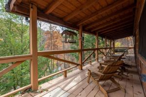 a porch of a cabin with chairs and trees at Outdoors Sleeps7 Family Getaway Fun Arcade Villa in Rockbridge