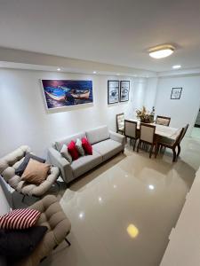 a living room with a couch and a dining room at Mar dos Anjos in Arraial do Cabo