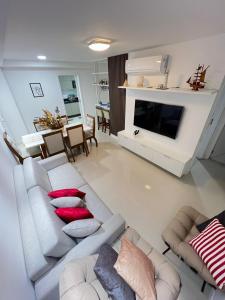 a living room with a couch and a tv at Mar dos Anjos in Arraial do Cabo