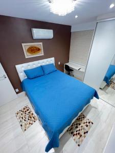 a bedroom with a blue bed and a desk at Mar dos Anjos in Arraial do Cabo +19 photos