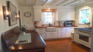 Una cocina con gabinetes blancos y una mesa de madera. en 637 Seagrove, en Cape May Point