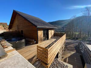 a house with a deck with a hot tub at Chalet iris & spa privatif in Rochesson