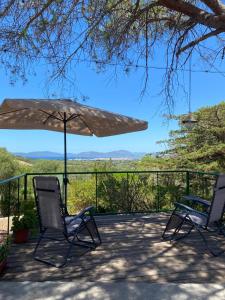 een terras met twee stoelen en een parasol bij Casa Barraté l'Alguer in Alghero