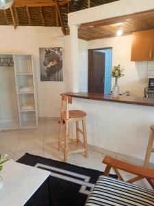 Una cocina y una sala de estar con mostrador y sillas. en The Makuti breeze house, en Mtwapa