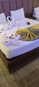 a bed with white sheets and flowers on it at Résidence touristique marcadal in Fort de lʼEau