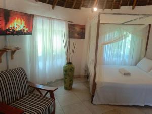 a bedroom with a bed and a chair and a vase at The Makuti breeze house in Mtwapa