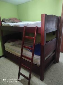 a wooden bunk bed with a chair next to a bunk bed at Apartamento perfecto en Merida Venezuela in Mérida +10 photos