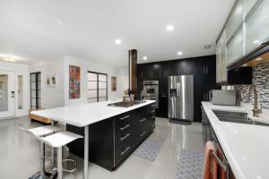a kitchen with black cabinets and white counter tops at UF SUNSHINE HOUSE - Patio & BBQ - Chef Kitchen - EV Car Station - Upscale Neighborhood! in Gainesville +26 photos