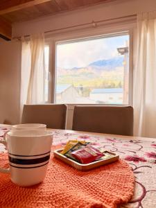 a cup of coffee sitting on a table with a window at Apart Patagonia Bolson in El Bolsón