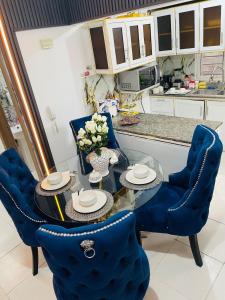 a dining room with blue chairs and a glass table at Luxury Apartment 10 mn to SDQ Airport, the beach in Ensanche Savica de Mendoza