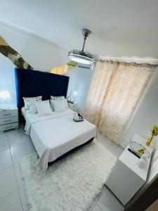 a bedroom with a bed with a blue headboard at Luxury Apartment 10 mn to SDQ Airport, the beach in Ensanche Savica de Mendoza +78 photos