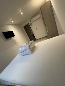 a room with a white bed and a mirror at Motel LU4 in Uckange +2 photos