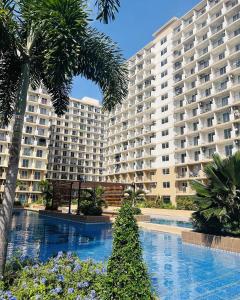 a large apartment building with a large swimming pool at Welcome to Cozy Staycation in Suba