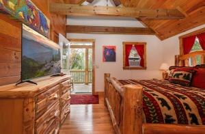 a bedroom with a bed and a large tv at Cozy Stone Cabin Retreat Near Beech Ski Slopes in Beech Mountain