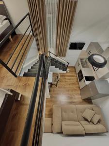 a living room with a couch and a staircase at Nest Apartments in Tirana +26 photos
