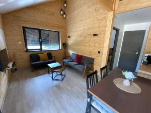 una sala de estar con un sofá y una mesa en Chalet muguet & spa privatif, en Rochesson