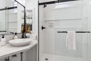 a white bathroom with a sink and a shower at Charming Canal Street Family Retreat in Heart of NOLA in New Orleans +12 photos