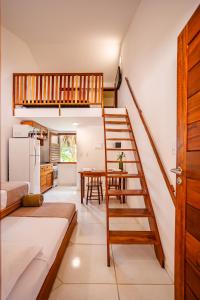 a living room with a spiral staircase and a kitchen at Villa das Palmeiras Jeri in Jericoacoara