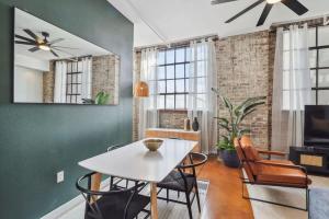 a dining room with a white table and chairs at Stylish Industrial Loft in Warehouse District in New Orleans