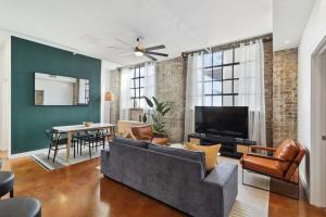 a living room with a couch and a tv at Stylish Industrial Loft in Warehouse District in New Orleans +19 photos