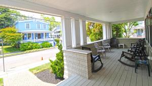 a porch with benches and chairs on a house at 209 Congress Street in Cape May