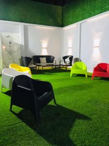 ein Raum mit bunten Stühlen und Tischen auf grünem Gras in der Unterkunft Résidence touristique marcadal by Mon rêve in Fort de lʼEau + 1 Foto