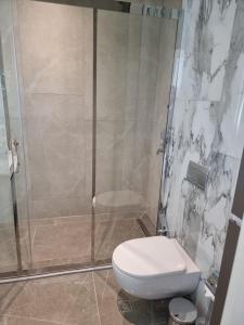 a bathroom with a toilet and a glass shower at Modern 1-Bedroom Apartment at Sea Breeze Park Residences 2, Just Steps from the Beach, with Pool, Gym, Restaurants and Free Parking in Nardaran
