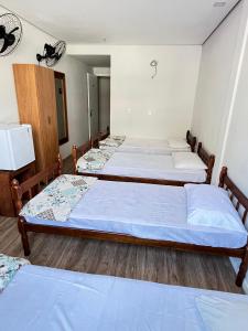 a group of three beds in a room at Stratus Centro Suítes Standard in Volta Redonda