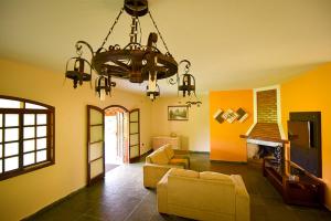 a living room with a couch and a chandelier at Pousada Recanto da Fazenda in Pinhalzinho