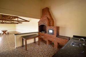 a brick oven in a room with a table at Pousada Recanto da Fazenda in Pinhalzinho