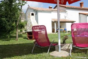 KršanにあるHouse Ivanaの庭の傘下に座る椅子2脚