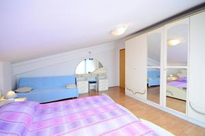 een slaapkamer met een blauw bed en een spiegel bij Apartments Biserka in Štanga