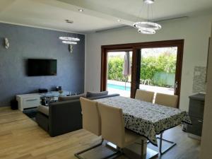 een eetkamer en woonkamer met een tafel en stoelen bij House Klaudio in Štanga