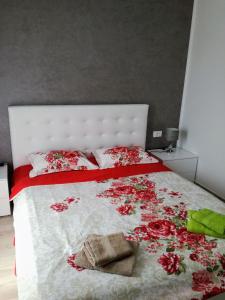 een slaapkamer met een wit bed met rode bloemen erop bij House Klaudio in Štanga