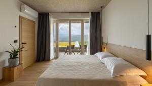 una camera da letto con un letto grande e una grande finestra di Villa Immortella a Rabac Altre 26 foto