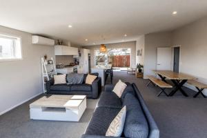 una sala de estar con un sofá y una mesa en Ocean Outlook - KK2565, en Kaikoura