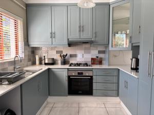 プレッテンバーグ・ベイにあるThe Nest at Castletonの白いキャビネットとコンロ付きオーブンを備えたキッチン