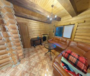 a living room with a leather couch and a table at Мʼята in Mykulychyn