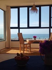 a dining room with a table and a view of the ocean at Appartement Michele Vue sur Mer pour les familles in Oualidia