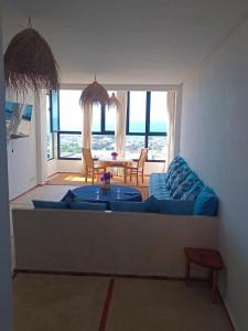 a living room with a blue couch and a table at Appartement Michele Vue sur Mer pour les familles in Oualidia