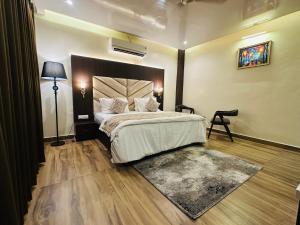 a bedroom with a large bed and a rug at Aruna Farm House in Kakarmatha +16 photos