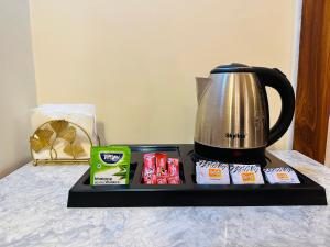 a tray with a coffee pot on a bed with a tea at Aruna Farm House in Kakarmatha