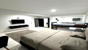 a bedroom with a large bed and a flat screen tv at Smart Loft Premium no Centro Moderno e Confortável in Presidente Prudente