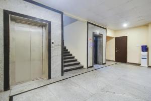a hallway with doors and stairs in a building at Hotel O Anuguna Tulasi Grand Near JNTU University Hyderabad in Hyderabad